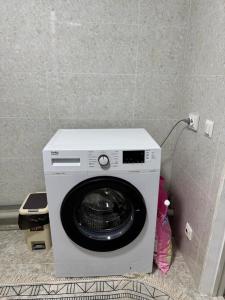a washing machine in the corner of a room at Ademi Guest House in Kochkorka