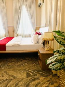 a bedroom with a bed with a window and a lamp at The Castle Private Villa in Aso +22 photos