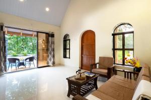 a living room with a couch and a table at StoneHaven 1BHK pvt Pool in Agashi