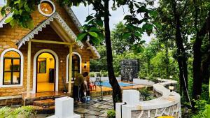 two people standing outside of a house with a pool at StoneHaven 1BHK pvt Pool in Agashi +26 photos