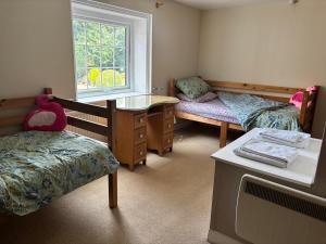 a room with two beds and a desk and a window at Saint Quintin Arms in Harpham