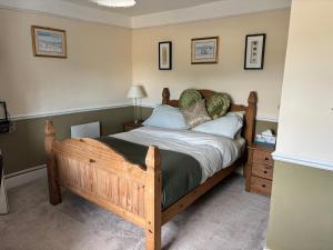 a bedroom with a wooden bed in a room at Saint Quintin Arms in Harpham