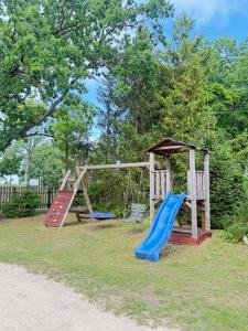 a playground with two swings and a slide at Domek u Franka in Smołdzino