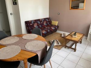 a living room with a table and a couch at La dame du bois in Gramat