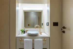 a bathroom with a sink and a mirror at Palazzo Venneri Lloyd - Historic Heritage Palazzo in Gallipoli