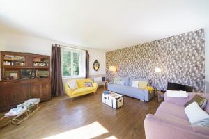 a living room with a purple couch and yellow chairs at Chez Sylvain in Issor