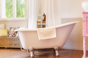 a white bath tub in a room with a window at Chez Sylvain in Issor +54 photos