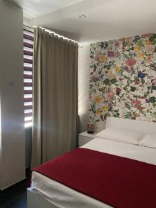 a bedroom with a bed with a floral wall at La Casa di PAT in Campobasso