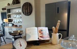 a book on a table with a clock and a scale at Orkney Retreats Island Farmhouses & Cottages in Sanday