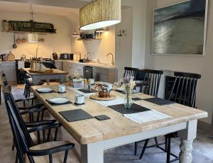 a kitchen with a large wooden table with chairs at Orkney Retreats Island Farmhouses & Cottages in Sanday