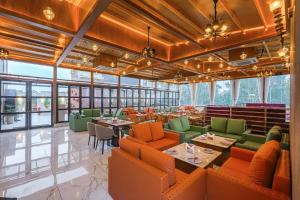 a restaurant with orange and green chairs and tables at The Roseville Grand Near Chandigarh University-Rayat Bahra University Kharar Chandigarh in Kharar
