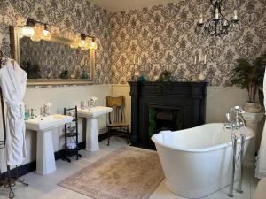 a bathroom with two sinks and a tub and a fireplace at Orkney Retreats Island Farmhouses & Cottages in Sanday +96 photos