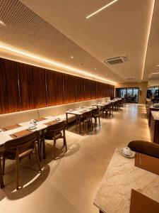 ein Restaurant mit Tischen und Stühlen in einem Raum in der Unterkunft Holanda Gold Hotel Praia de Tambaú in João Pessoa