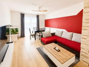 a living room with a red couch and a table at "LE PANORAMIQUE" en plein centre in Port-de-Bouc