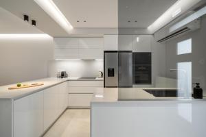 a white kitchen with white cabinets and appliances at Villa Occasus by A&D Properties in Porto Rafti