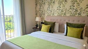 a bedroom with a bed with green pillows and a window at Alquilaeasy Marbella Views Ojen in Ojén +22 photos