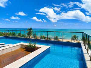 ein Swimmingpool mit Blick auf das Meer in der Unterkunft Holanda Gold Hotel Praia de Tambaú in João Pessoa