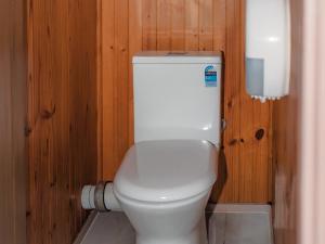 a bathroom with a white toilet in a wooden wall at Warburton Holiday Park in Warburton