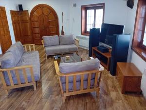 a living room with a couch and chairs and a tv at Villa Galicnik in Galičnik +17 photos