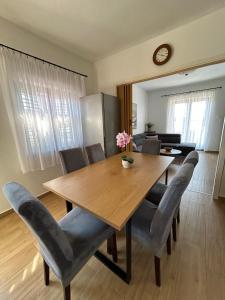 a dining room with a wooden table and chairs at Apartment Roko (10m from the beach) in Pašman
