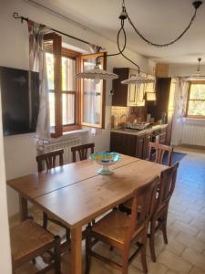 a wooden dining room table with chairs and a kitchen at I 23 PASSI Alfedena in Alfedena