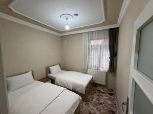a small room with two beds and a window at Kır Home in Çaykara