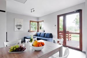 a living room with a table with a bowl of fruit on it at BIESZCZADZKI RAJ - DOM nad samym jeziorem, wysoki standard, basen, dostęp do wody, zielona plaża, motorówki, cisza i spokój in Olchowiec