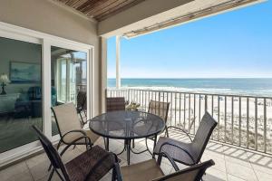 a balcony with a table and chairs and the ocean at Dolphin Key 3C in Orange Beach