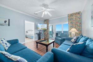 a living room with two blue couches and a table at Dolphin Key 3C in Orange Beach +40 photos