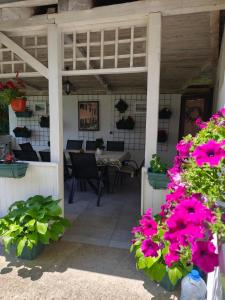 a patio with pink flowers and a table and chairs at Kuća JEKA in Vrnjačka Banja