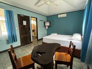 a bedroom with a bed and two chairs and a table at Hospedaje Las Cabañas in Batán