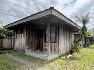 a small wooden house with a porch in a yard at Hospedaje Las Cabañas in Batán +6 photos
