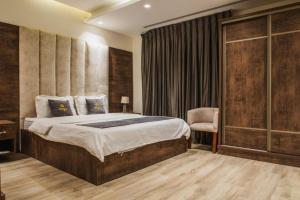 a bedroom with a large bed and a chair at Oriya Chalet - Molokai in Sowayma +16 photos