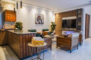 a kitchen and living room with tables and a tv at Oriya Chalet - Molokai in Sowayma