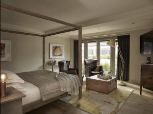 a bedroom with a bed and two chairs and a window at The Harper in Langham +70 photos