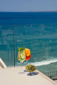 two cocktails sitting on a table next to the ocean at THE NICI Newquay in Newquay