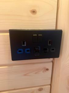 a black electrical outlet on a wooden door at Press Brook Park in Clay Cross