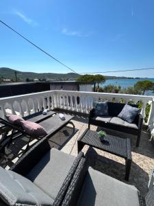 a patio with two chairs and tables on a balcony at Apartment Roko (10m from the beach) in Pašman