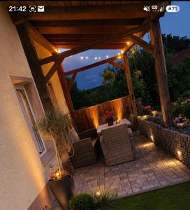a patio with wicker chairs and a pergola with lights at Ferienwohung M&A in Kulz