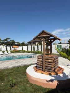 a wooden structure with a roof next to a pool at Sunset Garden Apartment 3 in Bilgah