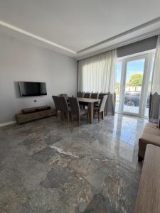 a living room with a table and chairs and a television at Sunset Garden Apartment 3 in Bilgah