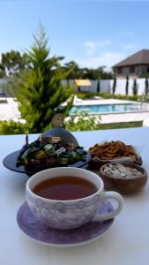 a cup of tea on a table with a plate of food at Sunset Garden Apartment 3 in Bilgah