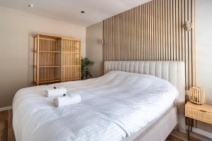 a bedroom with a large white bed with two towels on it at Luxury Apartment Knokke-Heist in Knokke-Heist