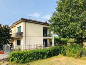 a white house with a fence and a tree at Casa Roberta a Lucca in Lucca +11 photos