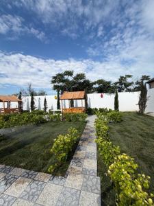 a garden with a house and a grass field at Sunset Garden Apartment 3 in Bilgah