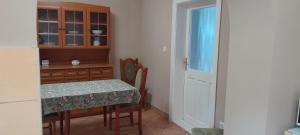 a kitchen with a table and a dining room at Zöld Udvar Pihenőház in Jászszentlászló