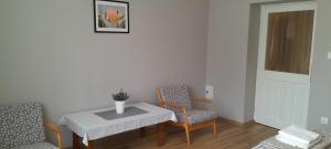 a living room with a table and two chairs at Zöld Udvar Pihenőház in Jászszentlászló