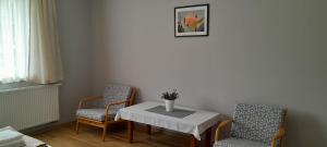 a dining room with a table and two chairs at Zöld Udvar Pihenőház in Jászszentlászló +18 photos
