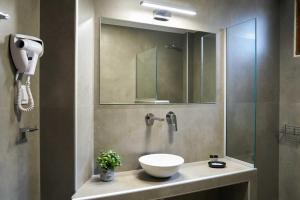 a bathroom with a sink and a shower with a mirror at Rodopi Hotel in Komotini