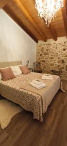 a bedroom with a large bed with a chandelier at Casa Paulina in Beceite